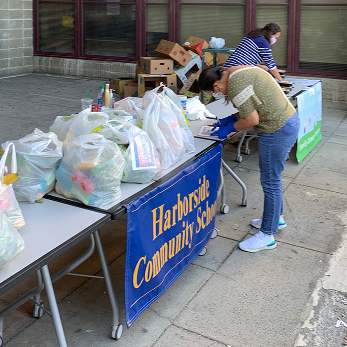 Volunteers set up for food distribution at East Boston Haborside Community school during the COVID-19 pandemic.